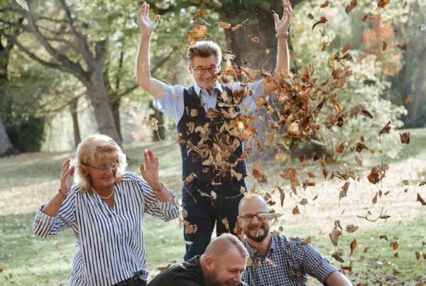 Leute spielen im Herbstlaub im Park.