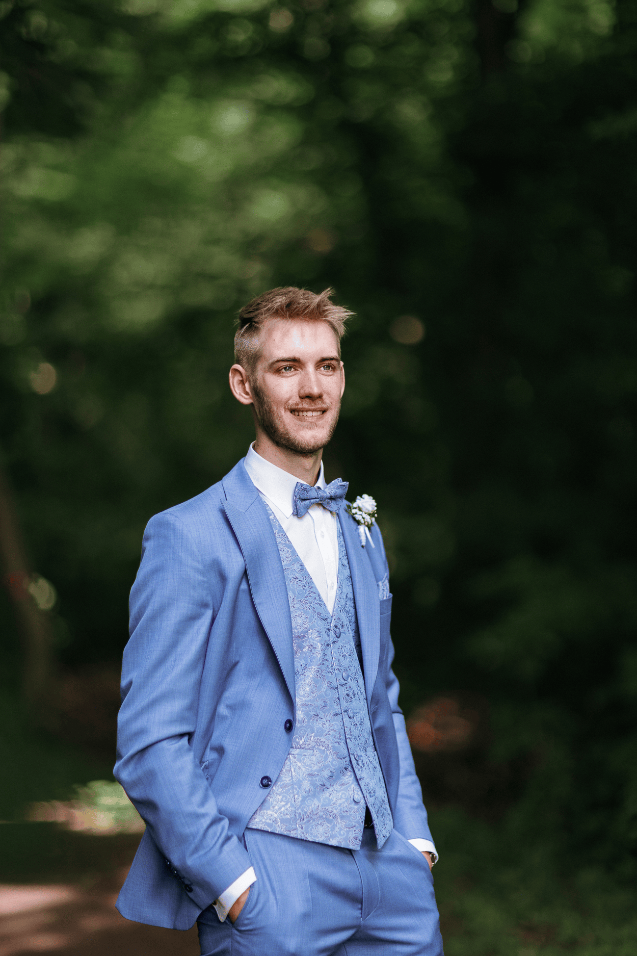 Bräutigam im blauen Anzug im Wald des Waldhaus Ölper