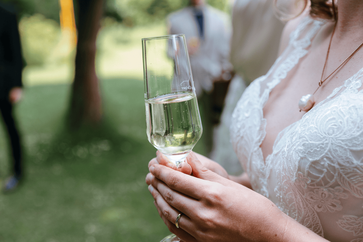 Braut hält ein Sektglas in der Hand
