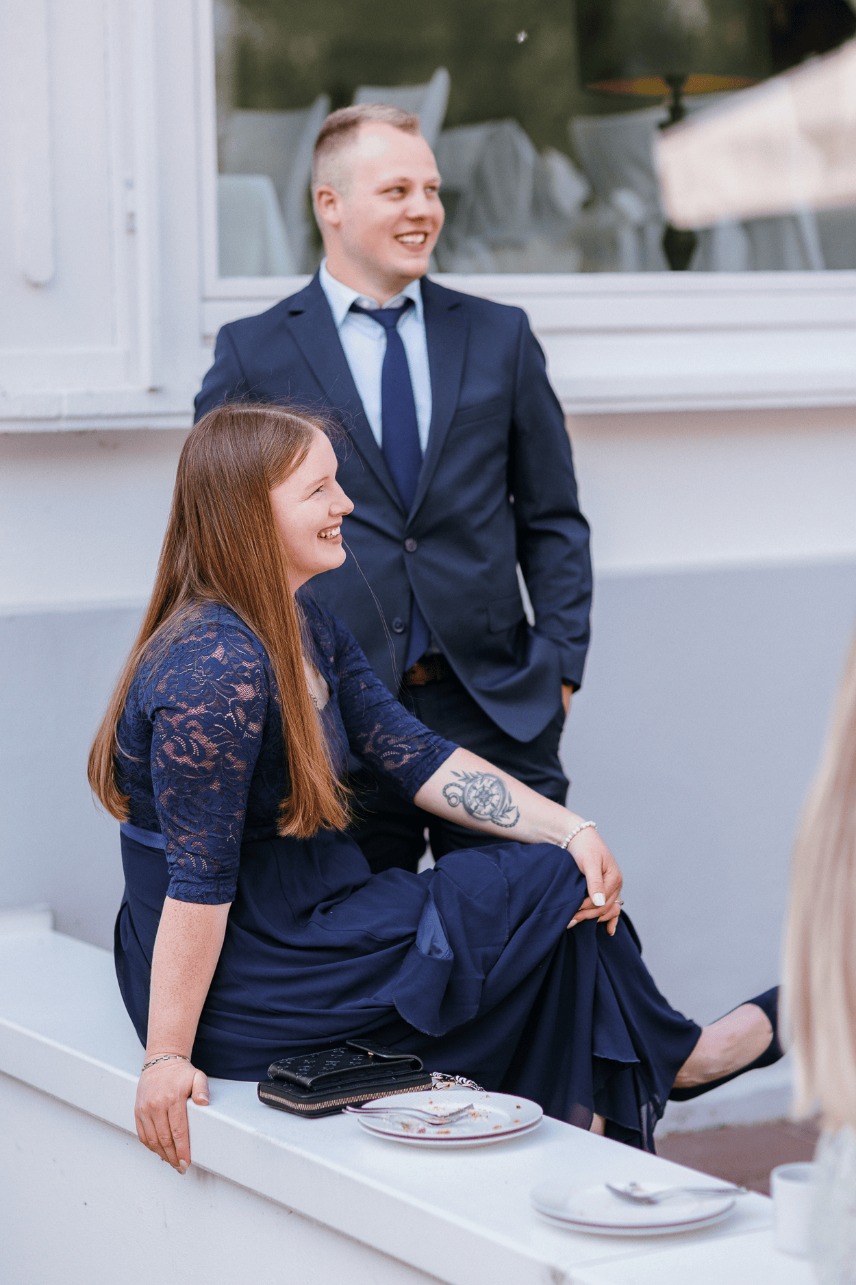 Zwei Personen in festlicher Kleidung lächeln.