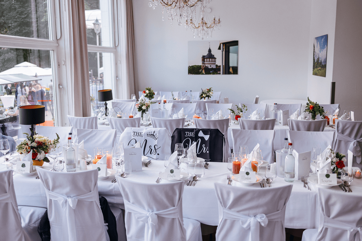 Hochzeitstafel festlich dekoriert mit weißen Tischdecken.